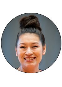 A woman with a bun is smiling for the camera.
