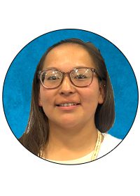 Person smiling with glasses and blue background.