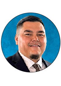 Smiling man in a suit against blue background.