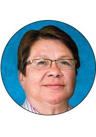 A woman with glasses is smiling for the camera.