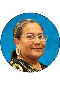 A woman with glasses is smiling for the camera.